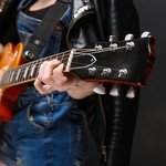 close-up-girl-s-hands-guitar-black-background