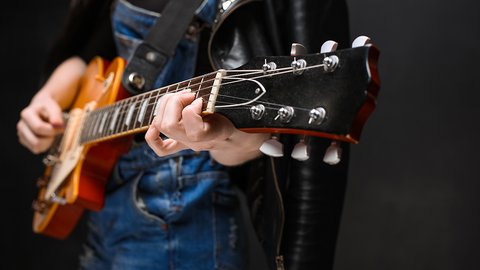 close-up-girl-s-hands-guitar-black-background