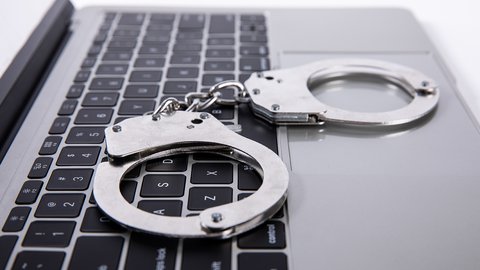 closeup-shot-handcuffs-lying-laptop-keypad-online-crime-concept