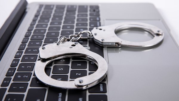 closeup-shot-handcuffs-lying-laptop-keypad-online-crime-concept