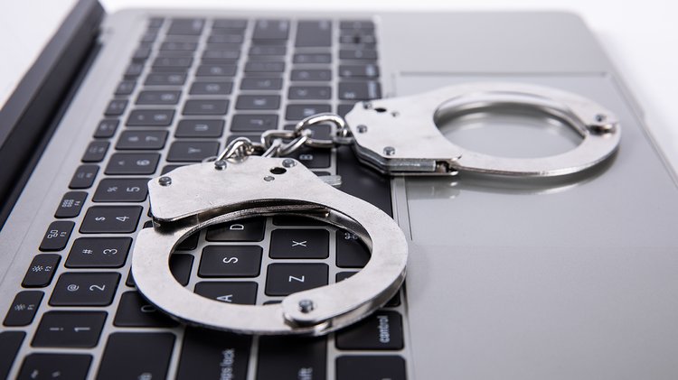 closeup-shot-handcuffs-lying-laptop-keypad-online-crime-concept