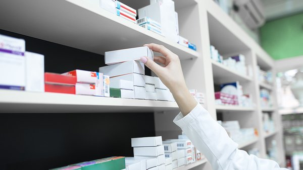 closeup-view-pharmacist-hand-taking-medicine-box-from-shelf-drug-store