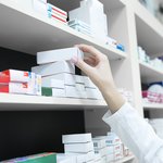 closeup-view-pharmacist-hand-taking-medicine-box-from-shelf-drug-store