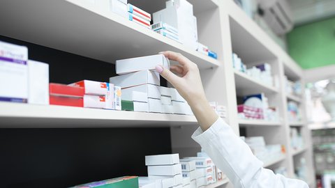 closeup-view-pharmacist-hand-taking-medicine-box-from-shelf-drug-store