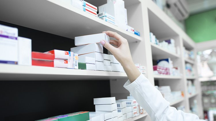 closeup-view-pharmacist-hand-taking-medicine-box-from-shelf-drug-store