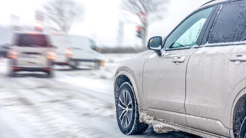 crossover-winter-slush-near-intersection-with-blurred-traffic-urban-safety