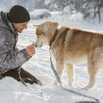 full-shot-man-with-dog-snow