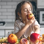 funny-little-girl-eating-apples-kitchen-health-nutrition-concept
