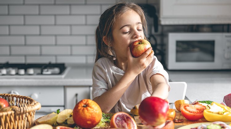 funny-little-girl-eating-apples-kitchen-health-nutrition-concept