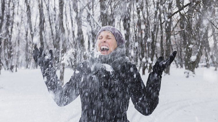 happy-young-woman-enjoying-snowfall-winter-forest