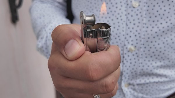 В руках Дмитрия копия немецкой зажигалки, оргинал он передал в музей