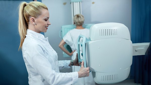 mid-adult-smiling-nurse-taking-xray-patient-clinic
