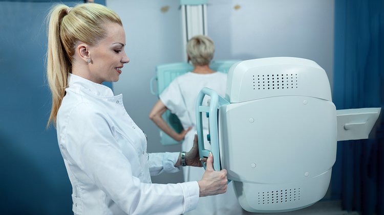 mid-adult-smiling-nurse-taking-xray-patient-clinic