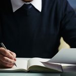 mid-section-unrecognizable-man-making-notes