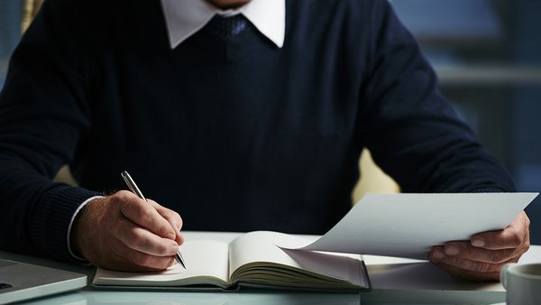 mid-section-unrecognizable-man-making-notes