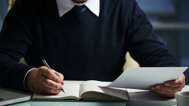 mid-section-unrecognizable-man-making-notes