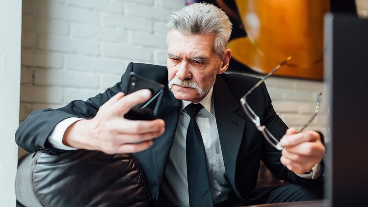 middle-aged-unhappy-businessman-modern-restaurant-using-laptop-phone