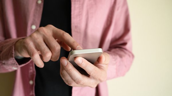 neuznavaemyi-muzcina-derzit-smartfon-i-kasaas-ekrana