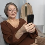 scastlivaa-pozilaa-zensina-s-pomos-u-smartfona-v-gostinoi-sovremennoi-kvartiry