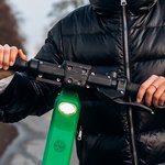 zensina-v-kurtke-na-elektriceskii-skuter-v-osennii-park